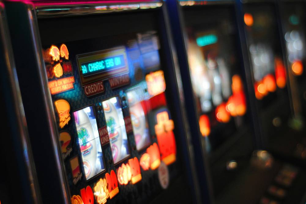 Layar mesin slot online dengan gulungan dan simbol keberuntungan